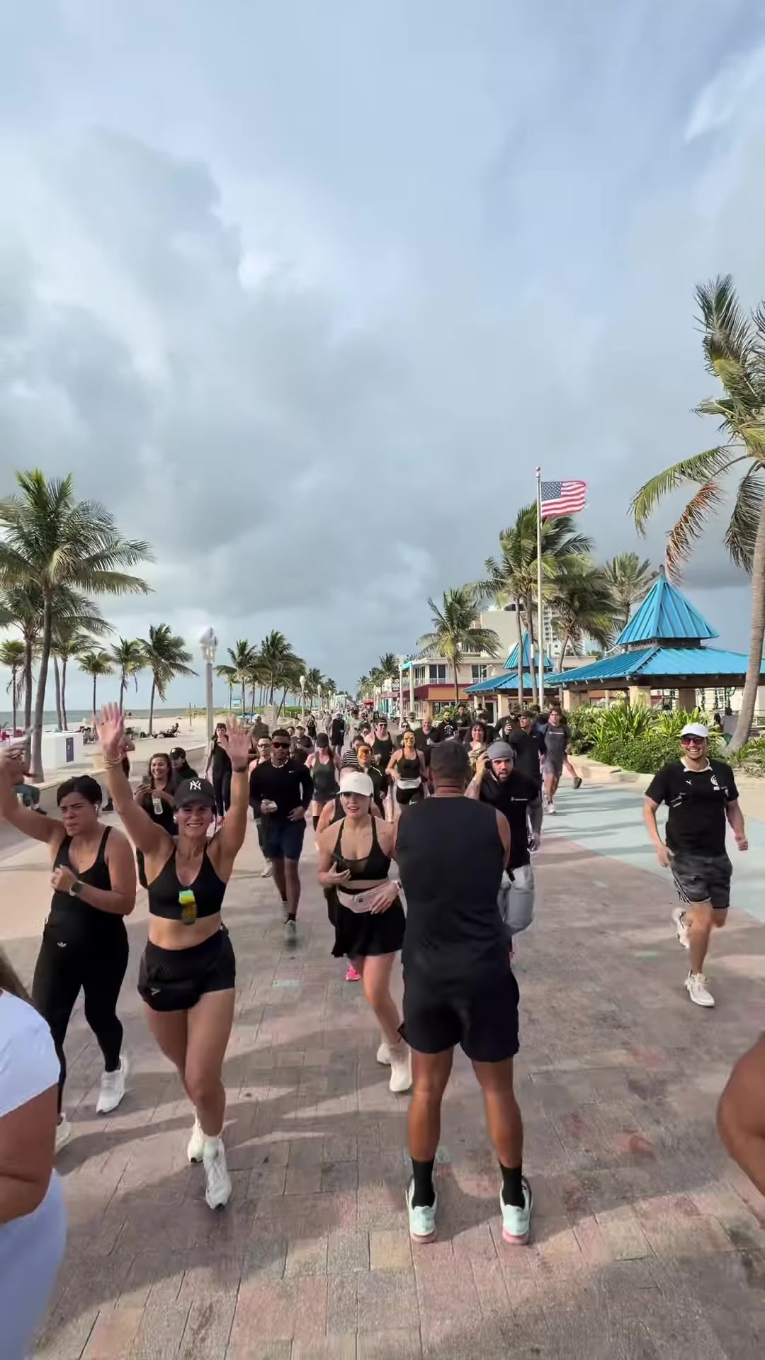 The crowd running down the beach broadwalk